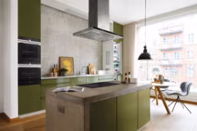 L'avantage de l'îlot est qu'il est possible de l'adapter à tous les besoins. Dans cette configuration, une hotte suspendue a été installée au-dessus de la plaque de cuisson à induction. Il est ainsi possible de cuisiner face à ses invités sans se couper d'eux.