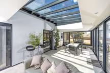 La véranda " Luciole » est dotée d'une toiture-terrasse avec des chevrons tubulaires à rupture de pont thermique. Semblables à des poutres apparentes, ceux-ci intègrent des spots lumineux.