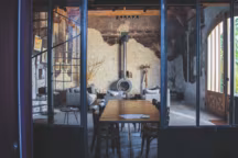 Dans le séjour, poêle Ateliers France Turbo, table en douelles de barrique et menuiserie sur mesure de la maison Guérin près de Chinon.