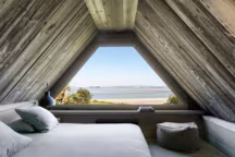 La chambre en mezzanine du cottage La Bergerie, maison indépendante de 45 m2, est entièrement lambrissée de bois et jouit d'une superbe vue sur la mer et l'estuaire
de la Seine.