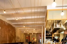 L'équipe de la Mercerie a confié l'aménagement du restaurant au duo Andreas Fragos-Victor Lecourtier. L'espace est structuré par un long comptoir en châtaignier et une rangée de tables dessinées par les architectes.