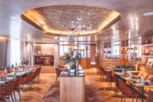 Le restaurant de 70 couverts offre un très beau volume qui s'organise de part et d'autre de l'îlot central et ménage également des espaces intimes, dans une ambiance à la fois chaleureuse et élégante, tout en marbre et en bois.