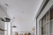 Toute en longueur, cette cuisine se pare d'acier inoxydable jusqu'à la verrière et les éléments de décoration pour créer une pièce moderne.