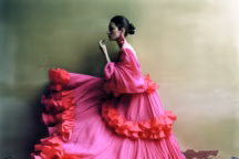 Macarena, dans une robe longue qui déploie plissés soyeux et volants foisonnants. Exubérance en rouge intense.