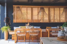 La cuisine d'été, avec ses ambiances vannerie et rotin pour la légèreté, bois et marbre pour le confort, donne sur le jardin et la piscine.