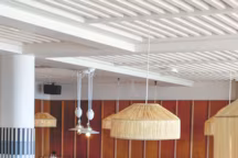 Sous les suspensions en jonc naturel ou porcelaine, banquettes au tissu C&C Milano, sièges en rotin.