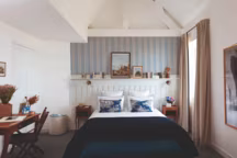 Dans les 31 chambres de l'hôtel, des papiers peints Jane Churchill ou C&C Milano déclinent plusieurs nuances de bleu, comme le jeté de lit en laine recyclée The Socialite Family.