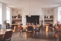 Dans le restaurant au décor sobre et élégant, une grande cheminée, des tables rondes en frêne de la région, au pied tronc d'arbre, réalisées par des amis artistes du couple, des chaises Baumann, modèle " Mondor », première édition, et des luminaires en laine.