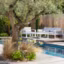 Un jardin méditerranéen avec terrasse en bois, piscine et salon de jardin