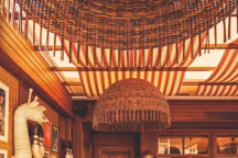 Chaises en rotin, carreaux de faïence verts, bois brûlé, marbre Verde Alpi... une relecture personnelle du style ethnique autour des belles matières.