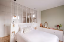 Utilisée comme tête de lit, cette verrière sur mesure permet à la salle de bains de profiter de la belle luminosité de la chambre. Réalisation Fanny Castillon