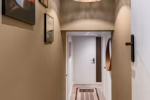 Grâce à une teinte vert brun appliquée sur la première partie du couloir, l'espace est devenu cosy et chaleureux.
